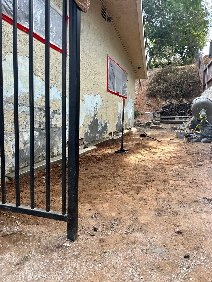 Painted stucco elevation with widespread delaminating material before restoration